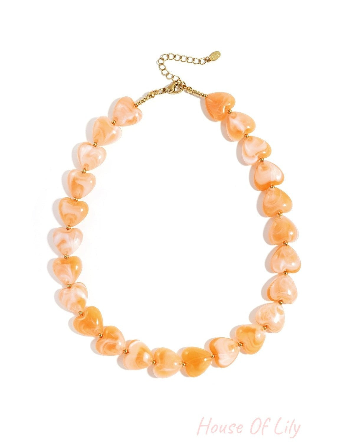Peach coral heart-shaped bead necklace with gold-tone spacers on white background