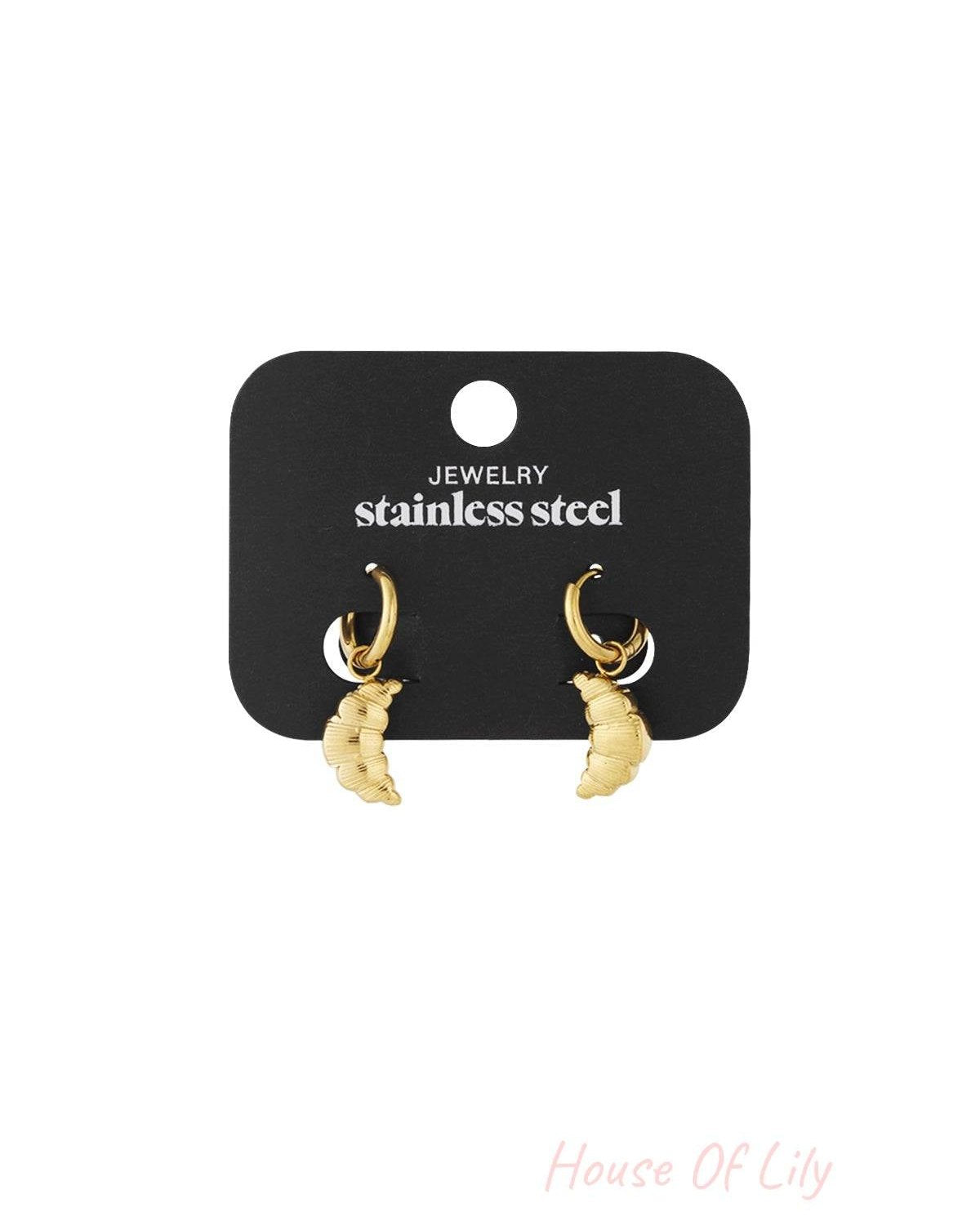 Gold stainless steel hoop earrings featuring dangling, textured croissant-shaped charms on a black display card.