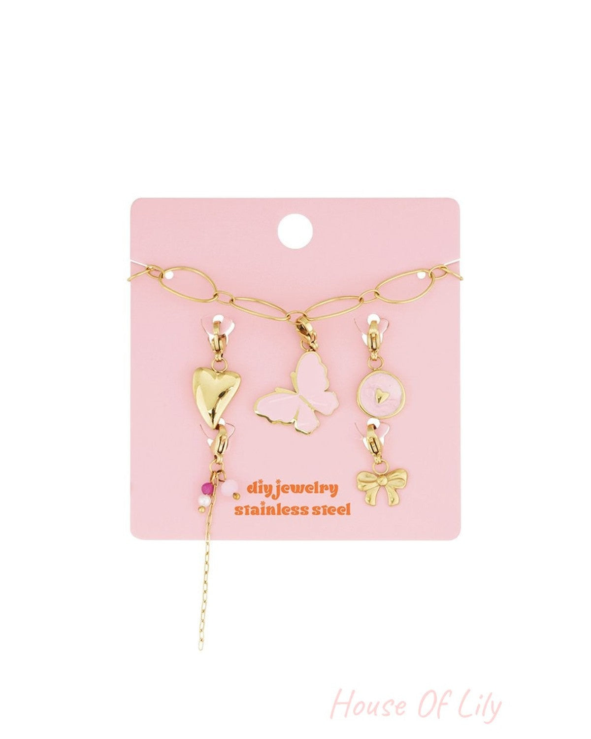 Elegant Gold Link Charm jewelry set featuring gold-toned butterfly, heart, bow, and bead charms on a pink card.