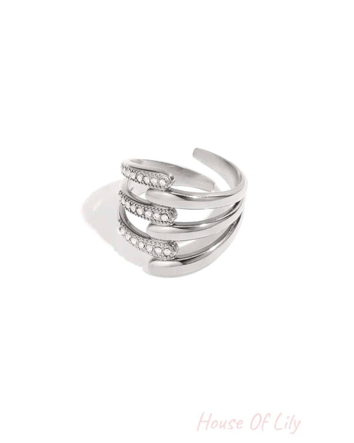 Silver-tone multi-band statement ring with rhinestone accents on white background
