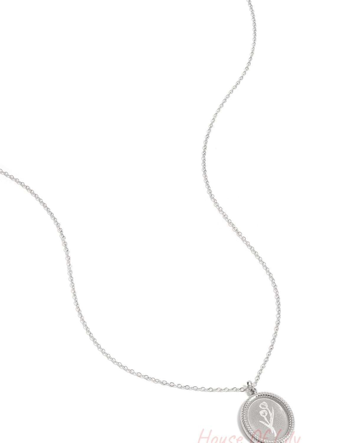 Close-up of silver tulip blossom pendant necklace on white background