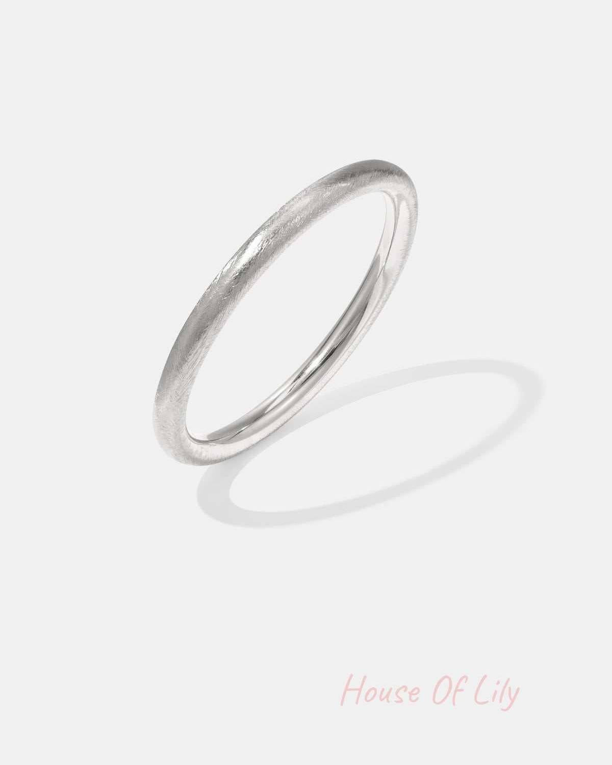 Silver minimalist bangle bracelet with a brushed texture on white background