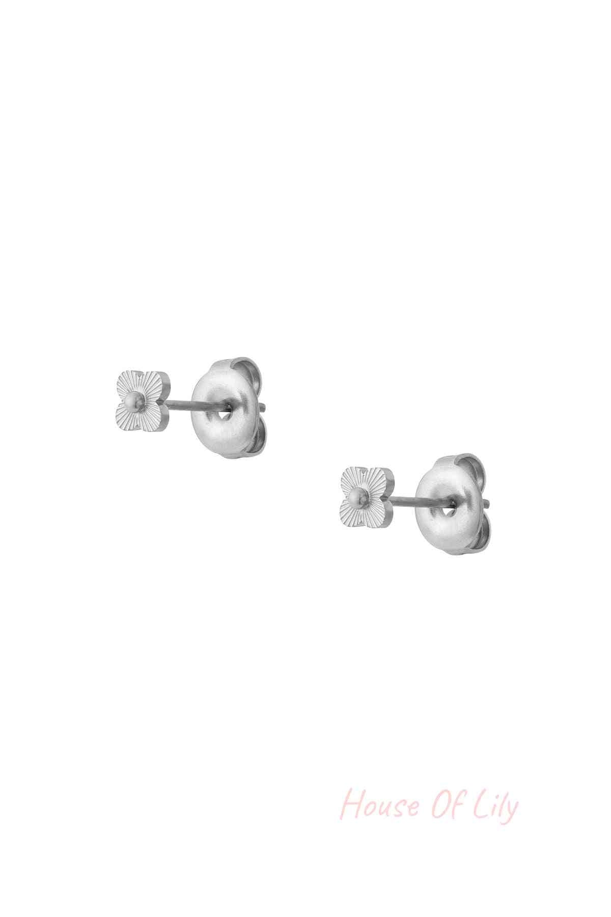 Close-up image of a pair of silver mini floral stud earrings with butterfly backings against a white background