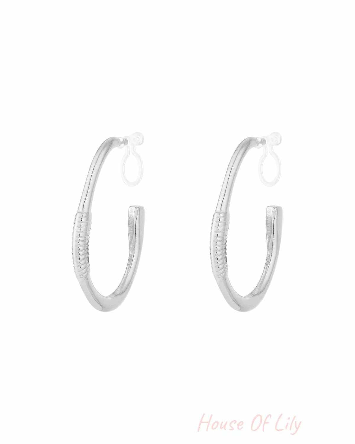 Pair of silver textured hoop clip-on earrings on white background