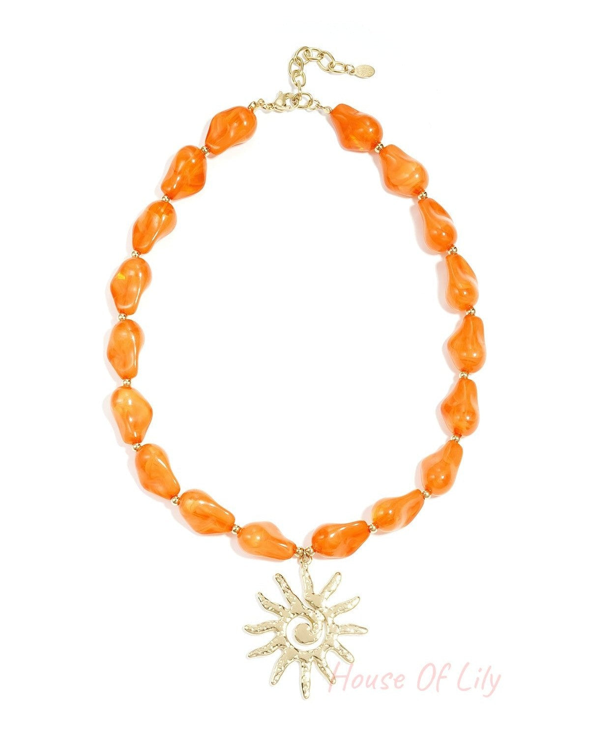 Vibrant orange acrylic beaded necklace with a textured gold sun pendant shown on a white background