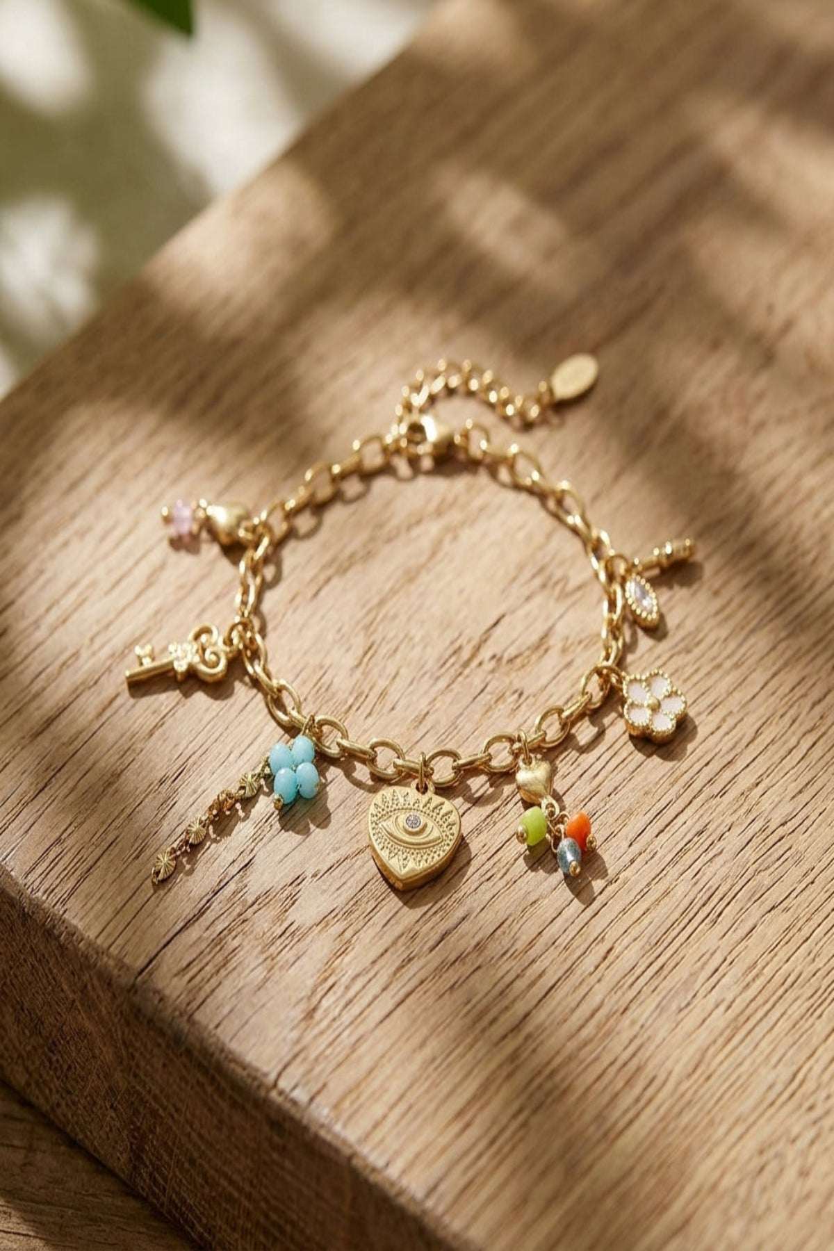Close-up of a tiny stainless steel secret love bracelet with a gold hue on a wooden surface, highlighting micro-texture and fine details.