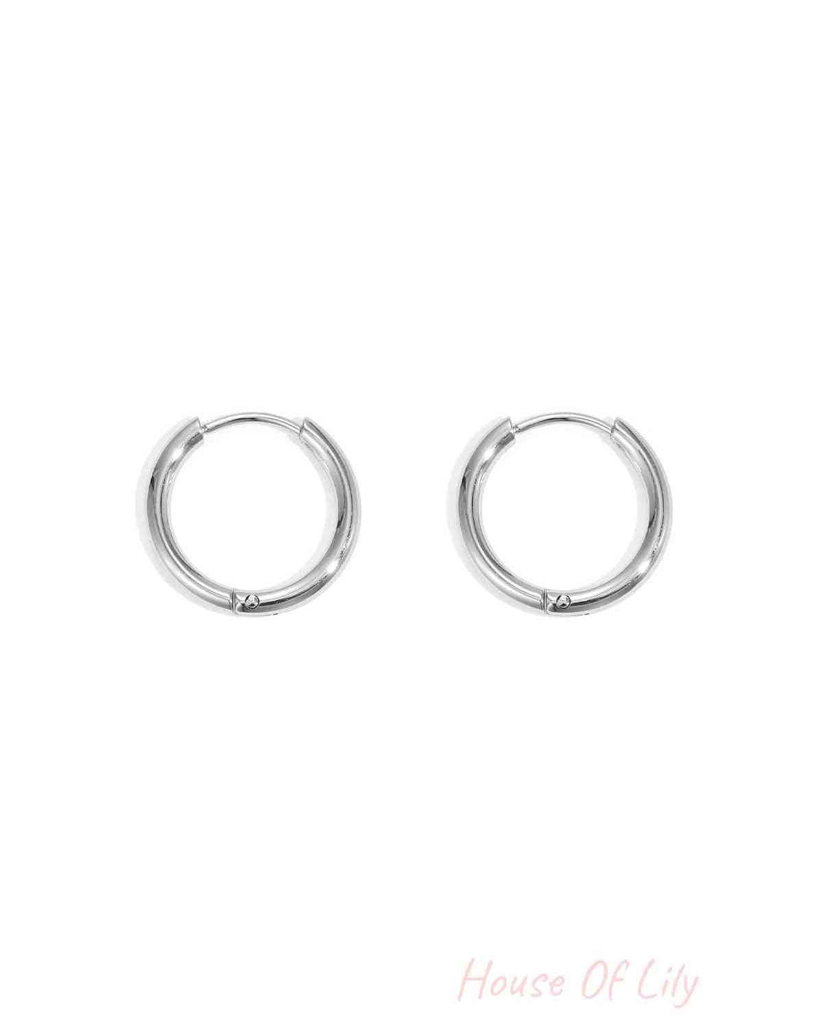 Pair of small silver hoop earrings with smooth rounded design set on a white background