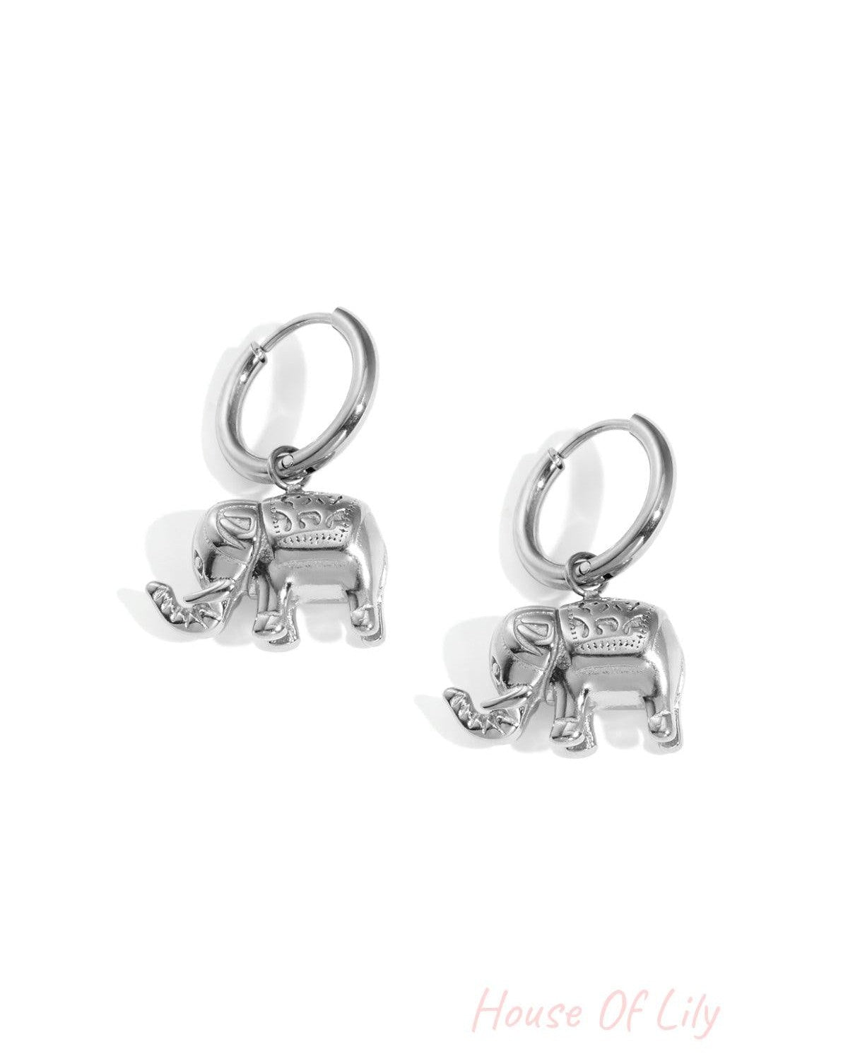 Pair of silver elephant charm hoop earrings on white background