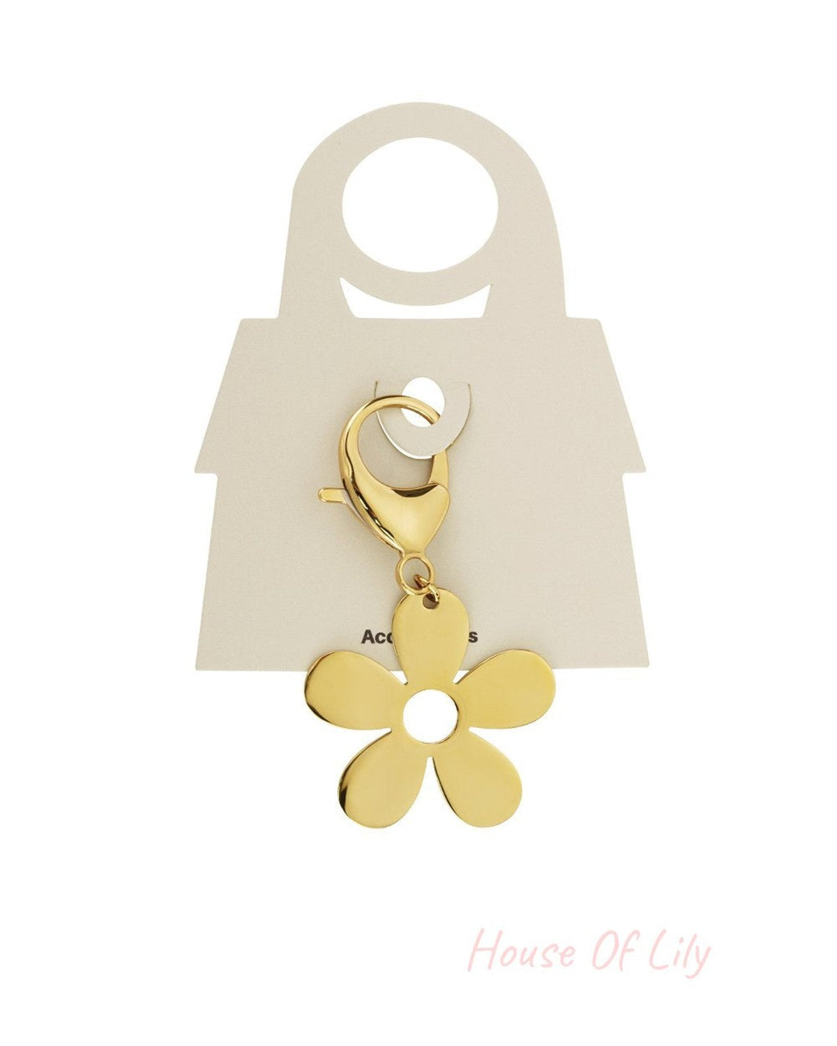 Shiny gold-tone flower charm with a circular center cut-out, attached to a lobster clasp on a display card.