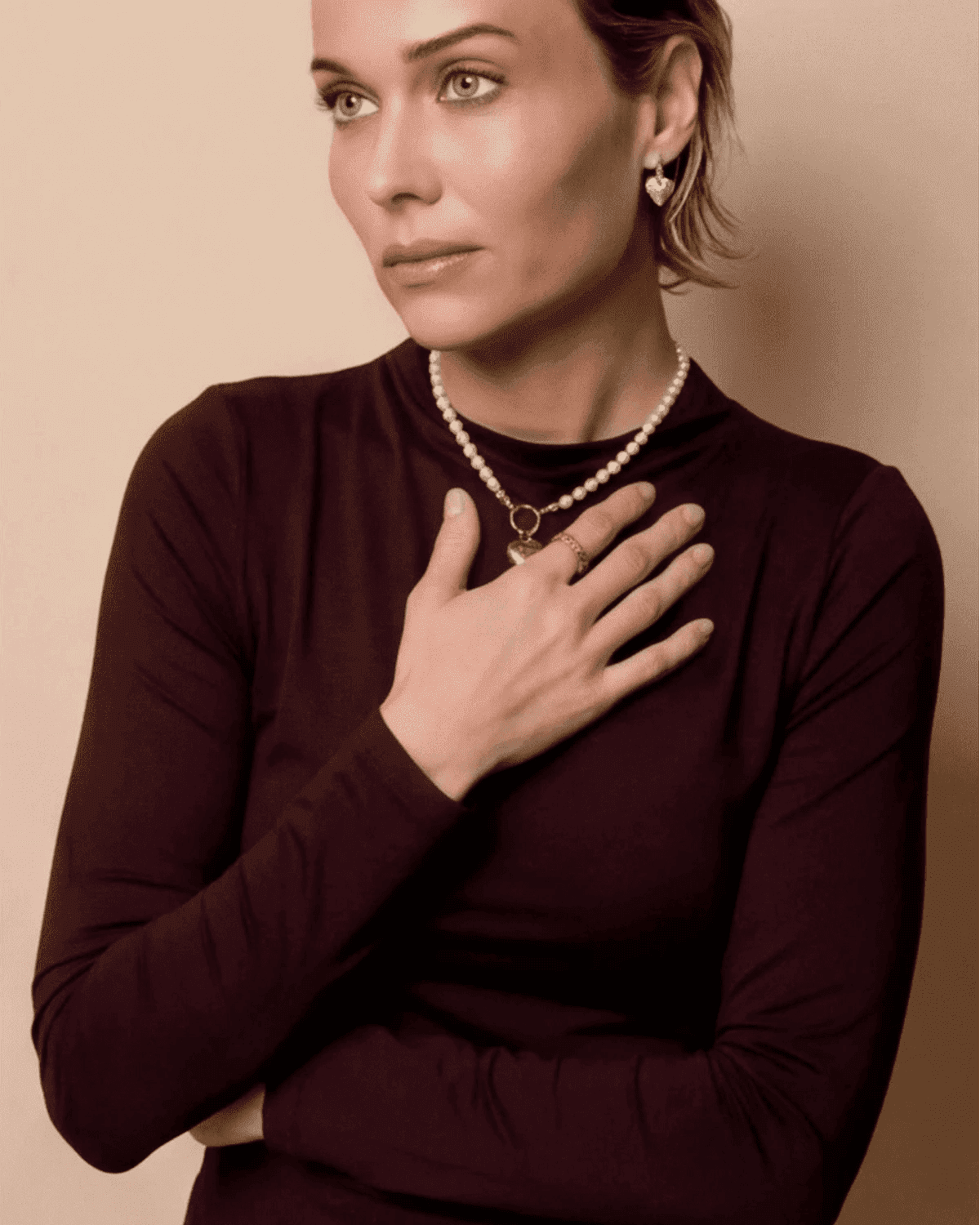 Model wearing Coquette Heart Hoops, small silver heart-shaped pendant earrings in a romantic, dainty style.