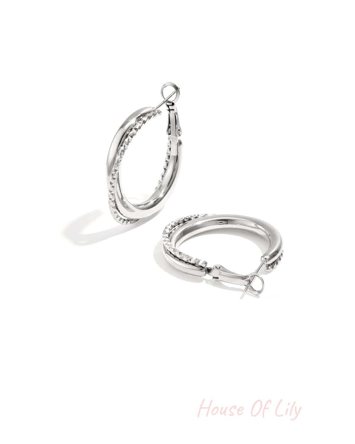 Silver twisted double hoop earrings featuring mixed polished and textured design, displayed on white background.