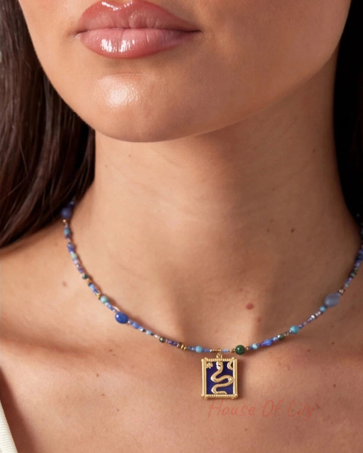 Necklace with a pendant worn by a person, focusing on the necklace and skin texture.