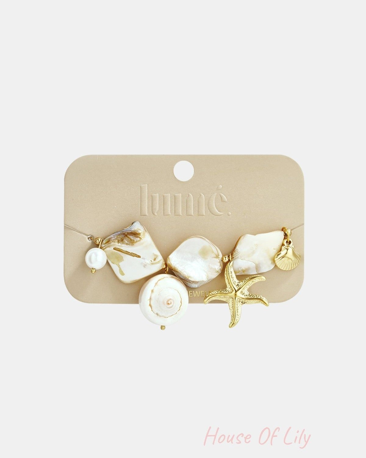 Mother Pearl Sea Charm bracelet featuring iridescent shell pieces, a gold starfish, and seashell charms on a display card.