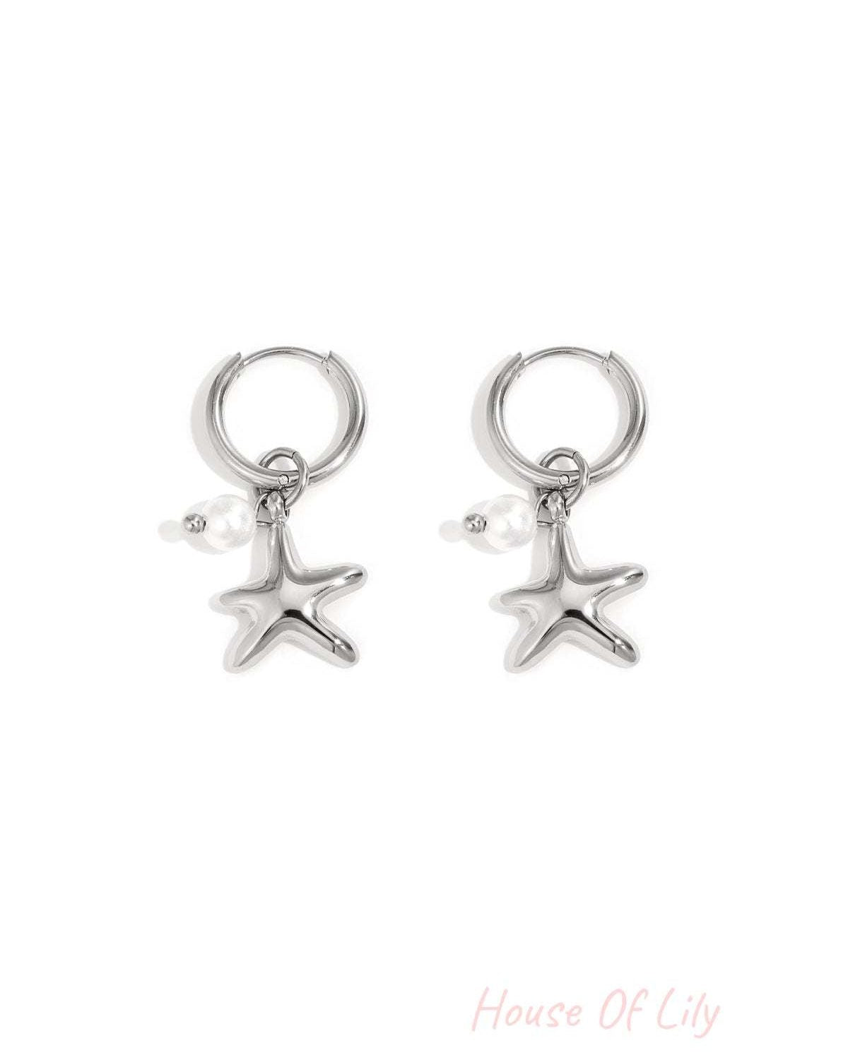 Pair of silver starfish charm hoop earrings with small pearl detail on white background