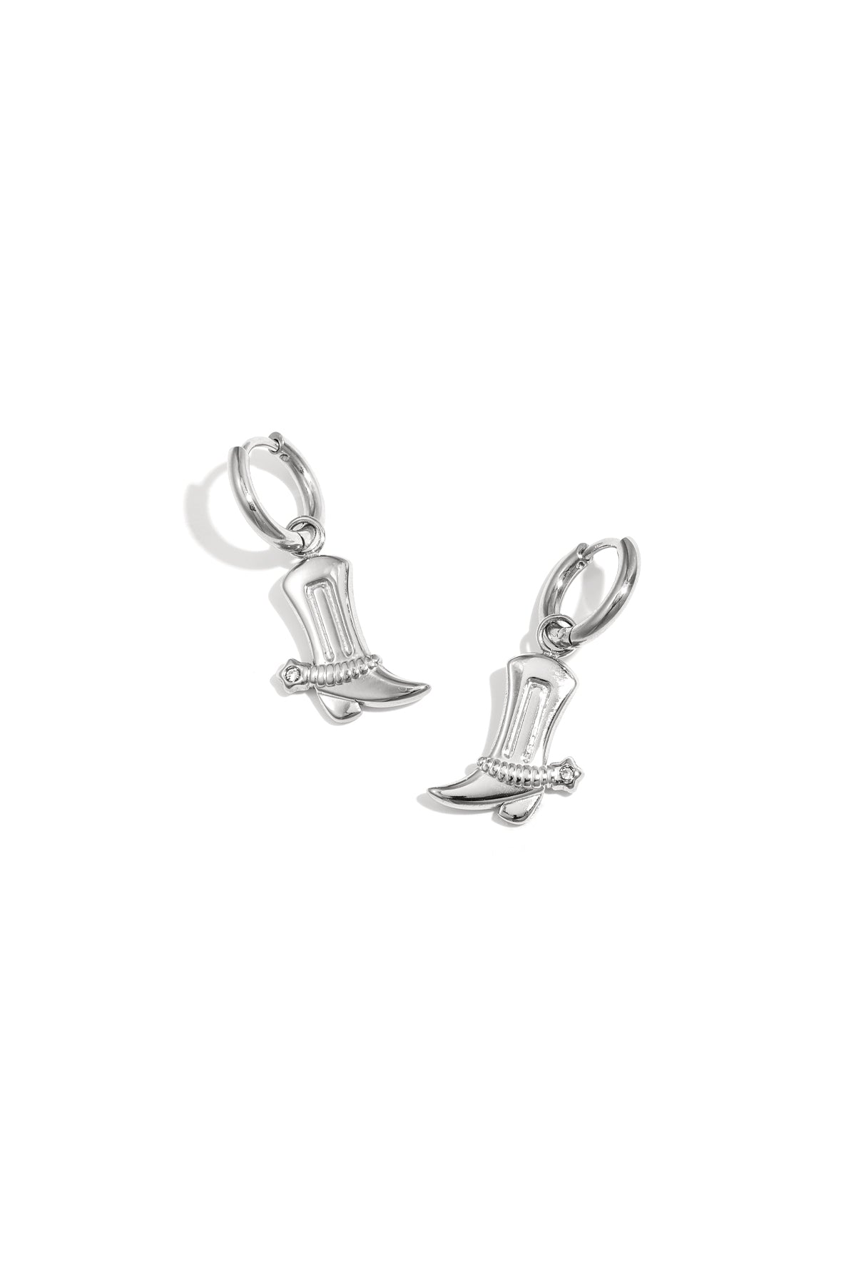 Pair of silver cowboy boot charm drop earrings with rhinestone detail on white background