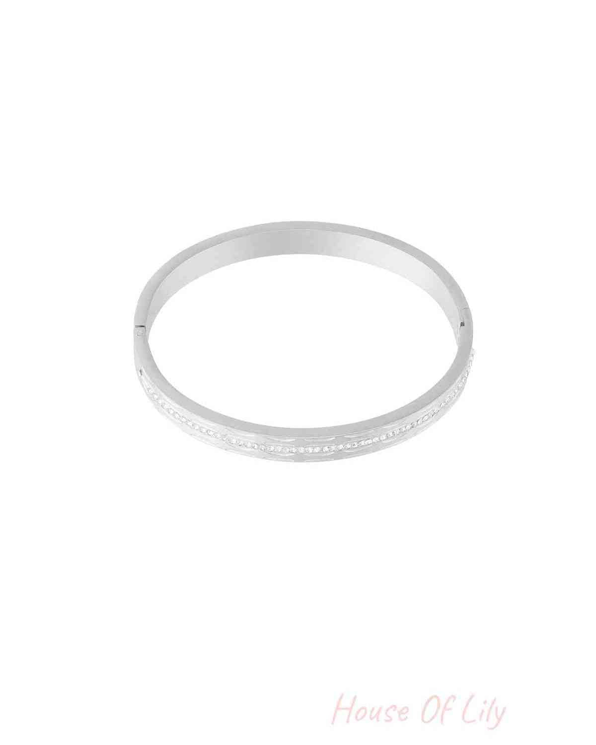 Single silver-tone bangle featuring a row of small sparkling crystals, isolated on white background