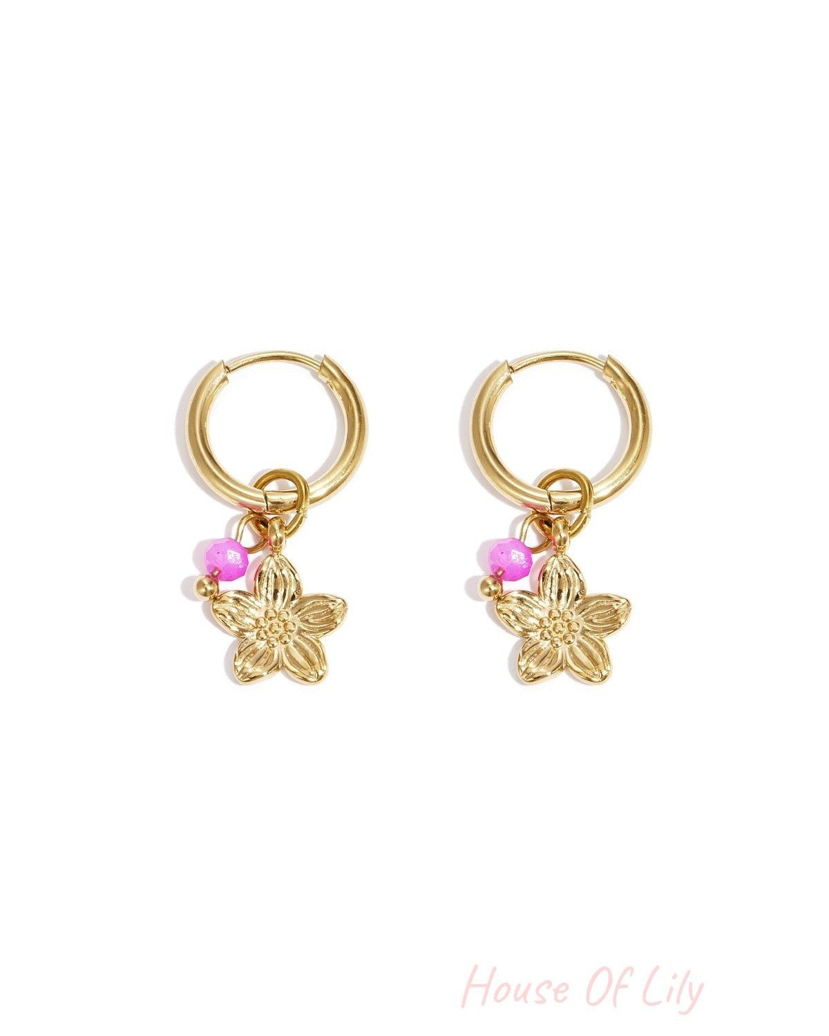Pair of gold hoop earrings with a gold flower charm and bright pink bead on white background