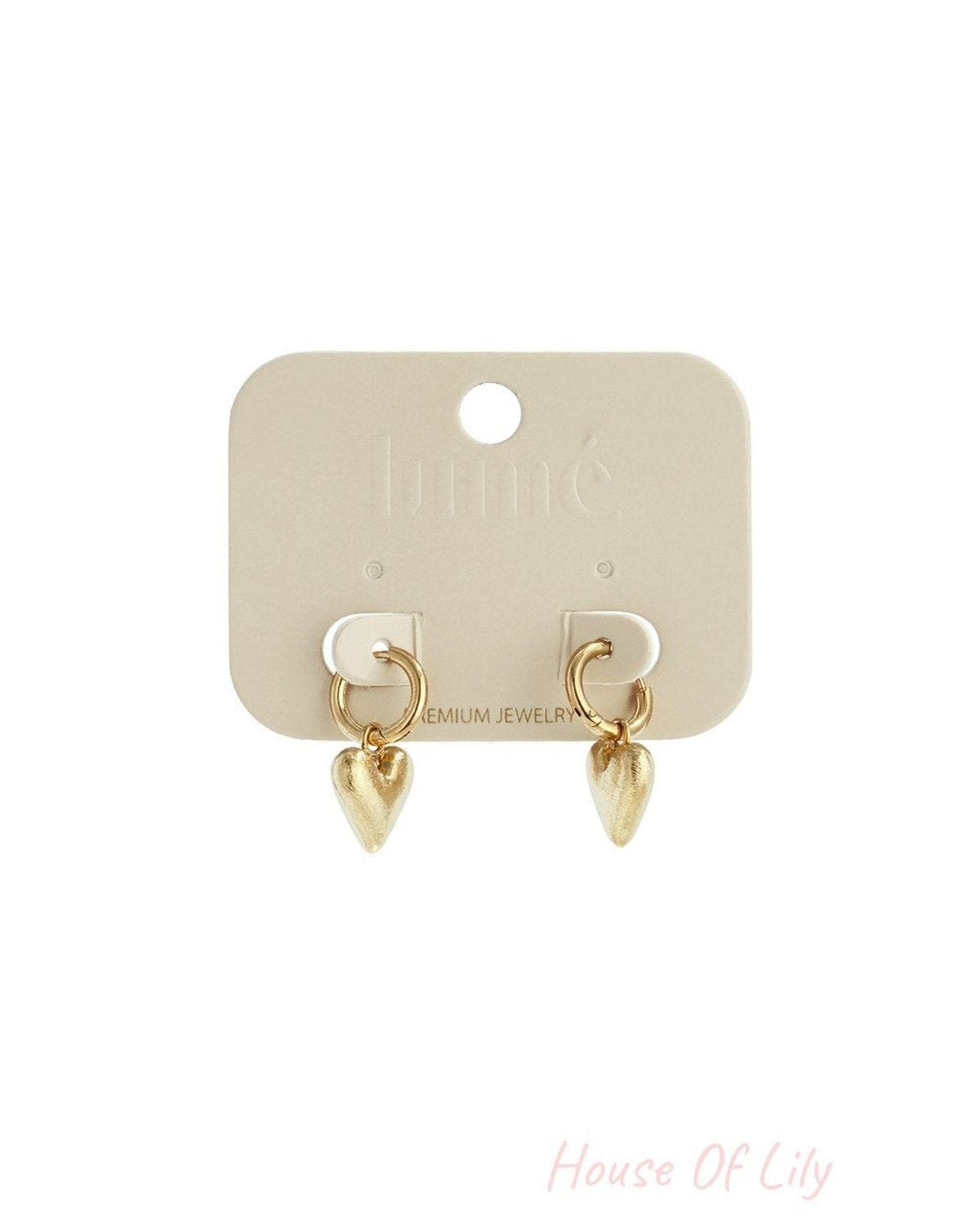 Gold hoop earrings with textured, heart-shaped charms attached to a beige display card.
