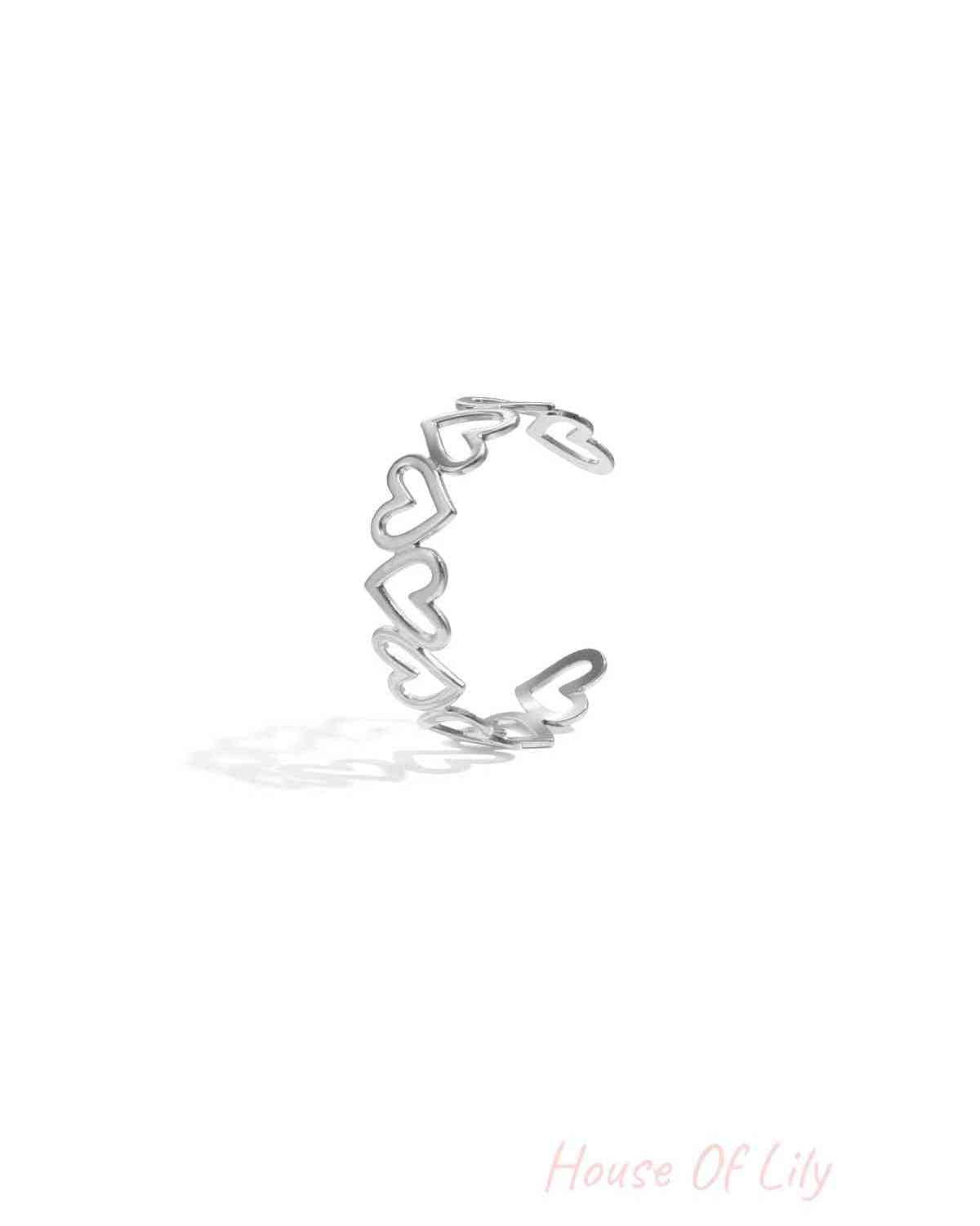 Silver-tone open cuff bracelet with linked hollow heart shapes displayed on white background