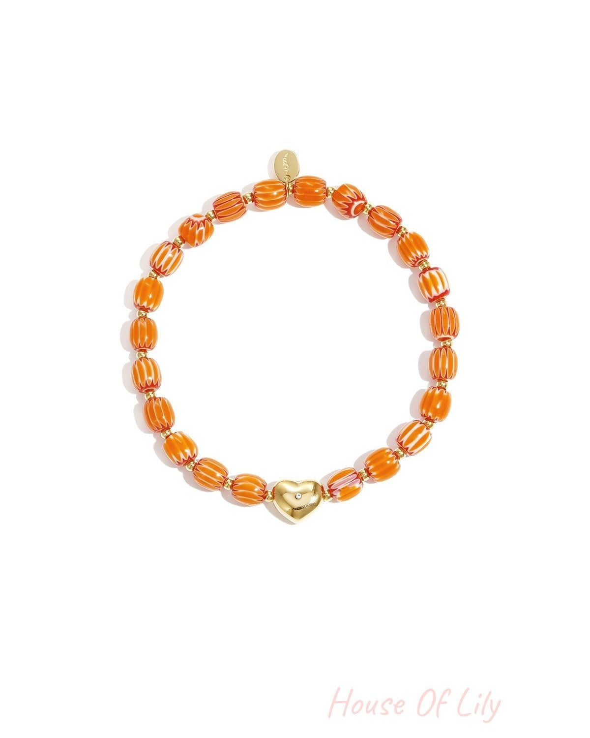 Orange and white striped beaded bracelet with gold heart charm laid flat on white background