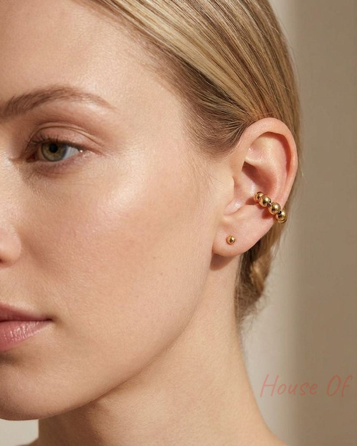 Delicate stainless steel Magic Touch Ear Cuff clipped on a female model's left ear, highlighting its shimmer in a minimalist indoor setting.