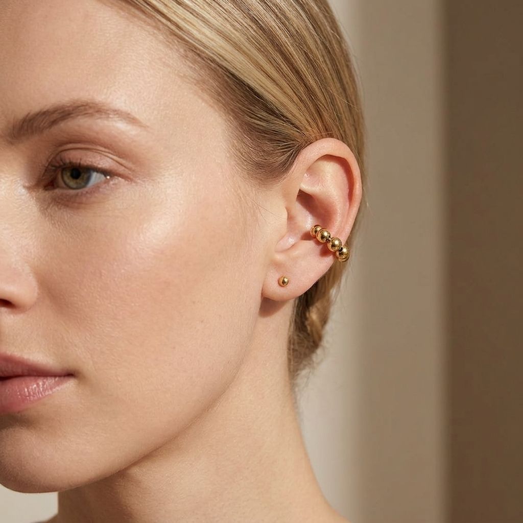 Delicate stainless steel Magic Touch Ear Cuff clipped on a female model's left ear, highlighting its shimmer in a minimalist indoor setting.