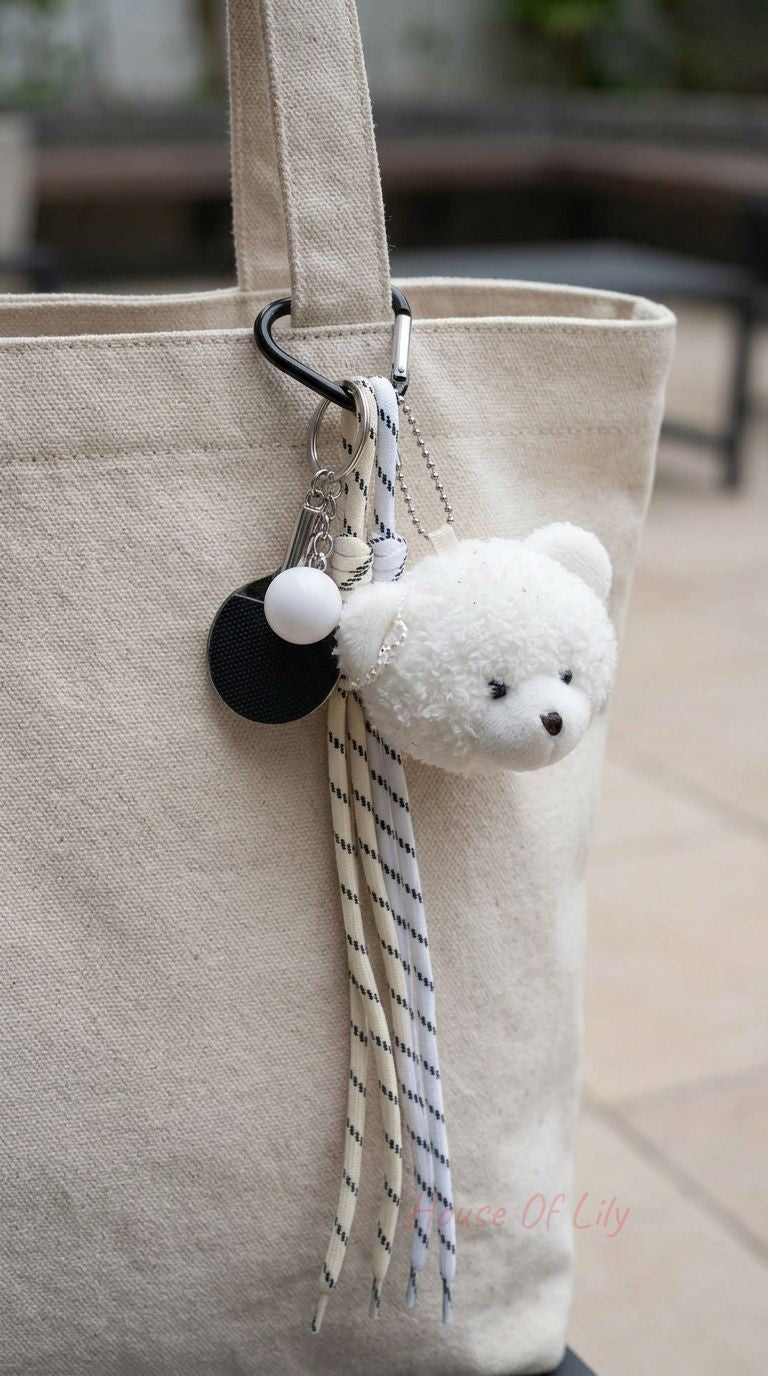 Full-body shot of the Plush Bear Bag Charm hanging from a bag strap on a textured surface, highlighting its cute design and realistic details.