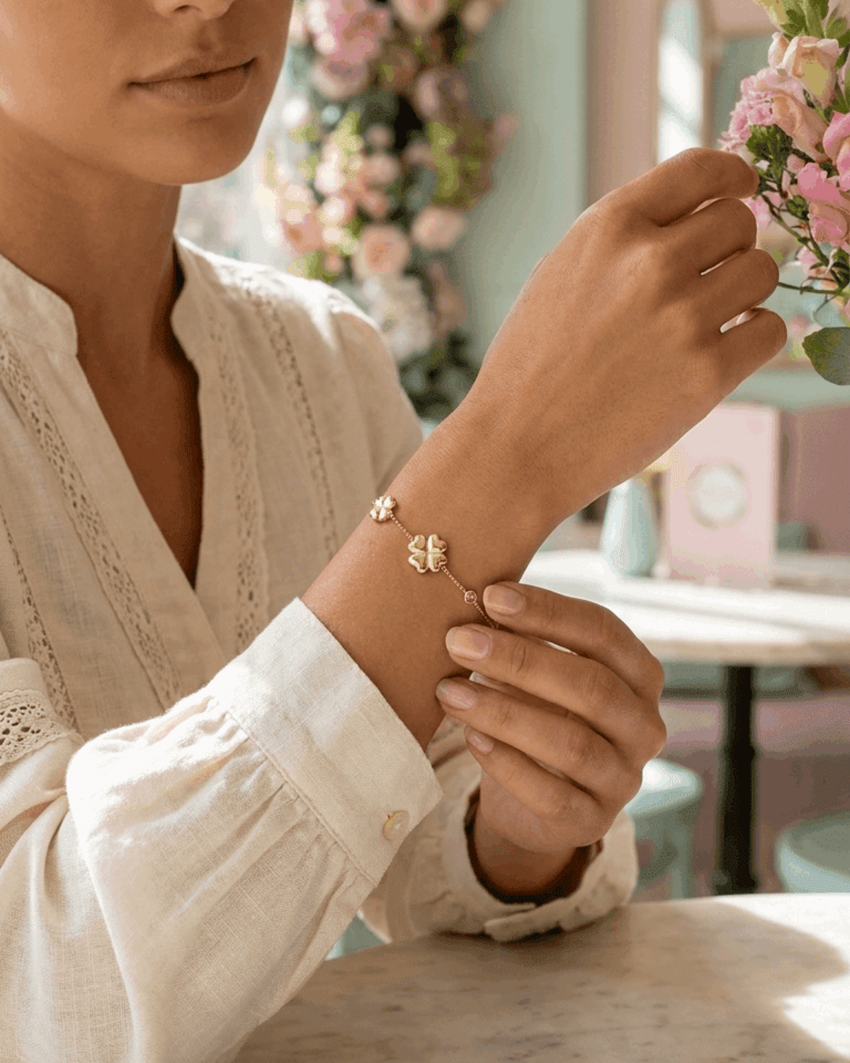 Lucky Clover Charm Bracelet in gold, featuring delicate clover charms and a tiny pink accent on a thin chain.