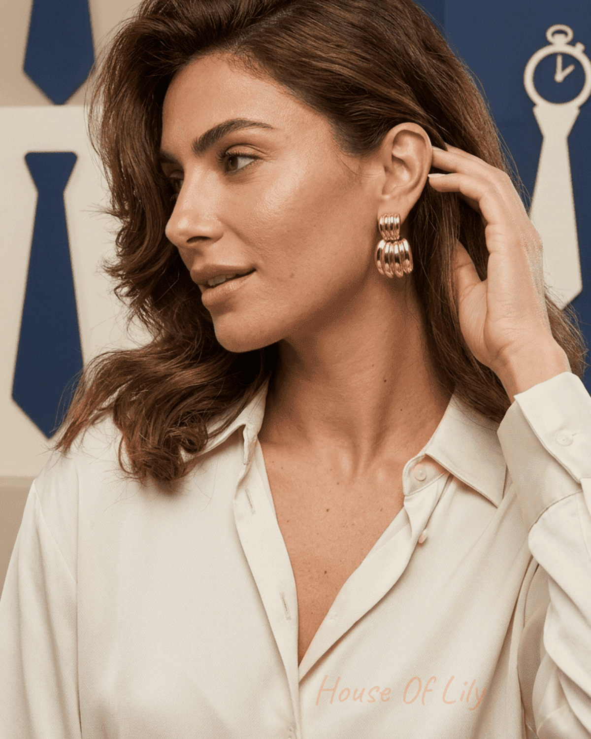Chunky Vibe gold-tone hoop earrings with a ribbed, multi-band texture on a woman wearing a cream button-down shirt.