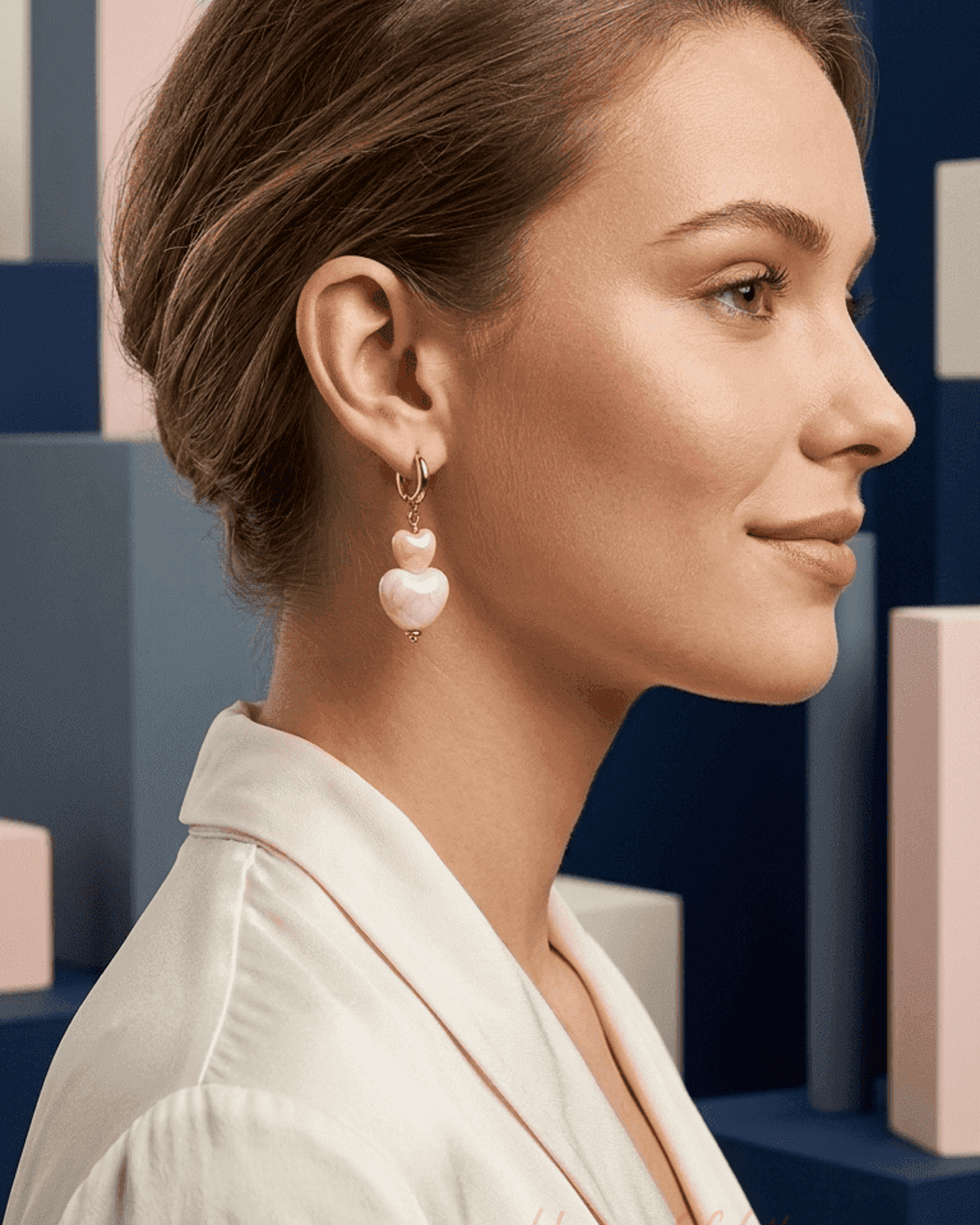 Woman wearing Bubblegum Heart Drip earrings: gold hoops with stacked, light pink marble-effect heart charms.