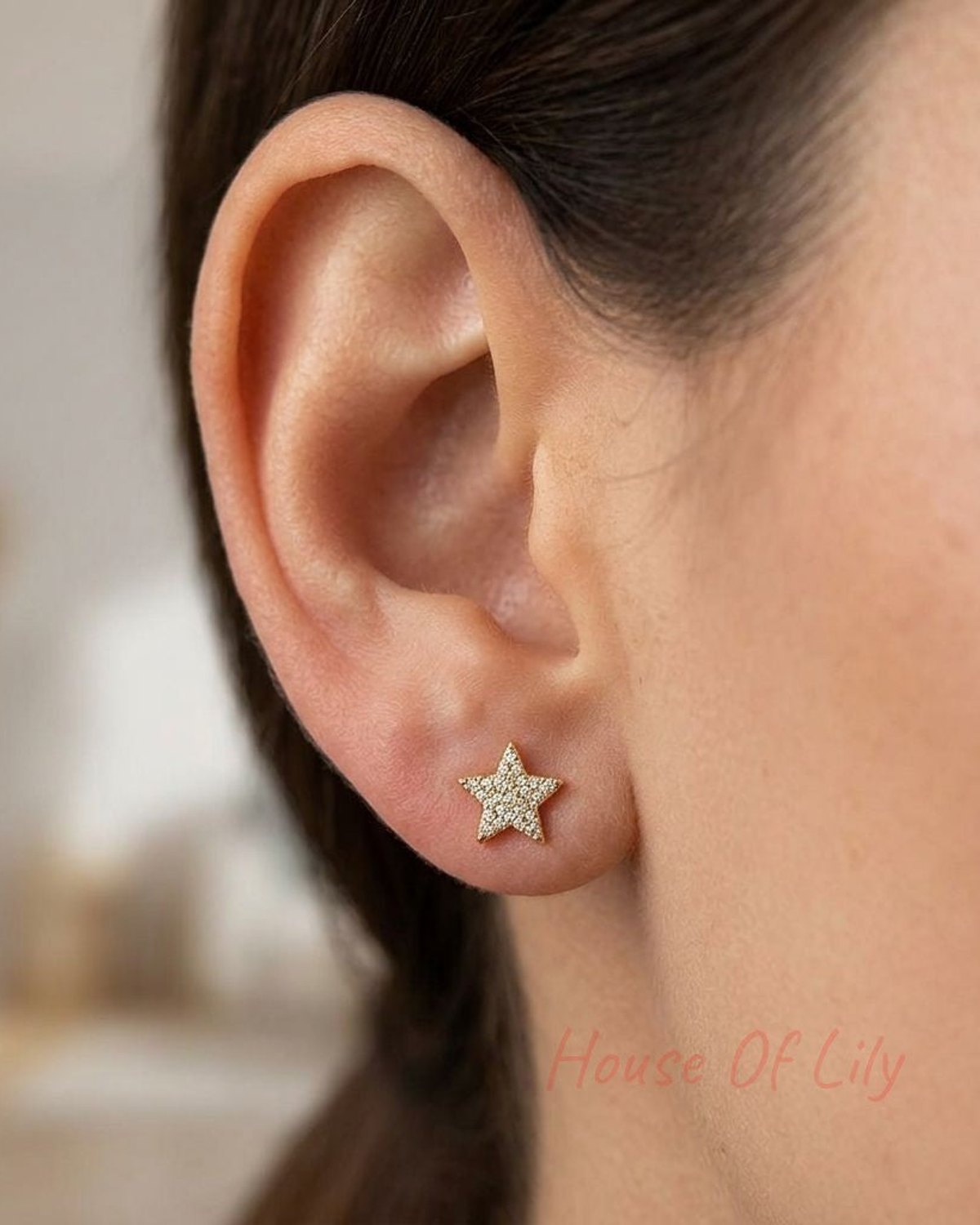 Close-up of Starry Night Studs earrings on a model's earlobe, showcasing lightweight star design with zircon inlays and subtle shimmer.
