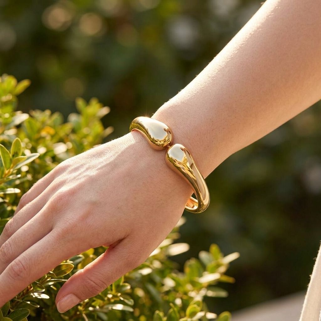 Wavy Twin Bangle worn on a model's wrist outdoors, showcasing its dainty design and irregular shape in warm daylight.