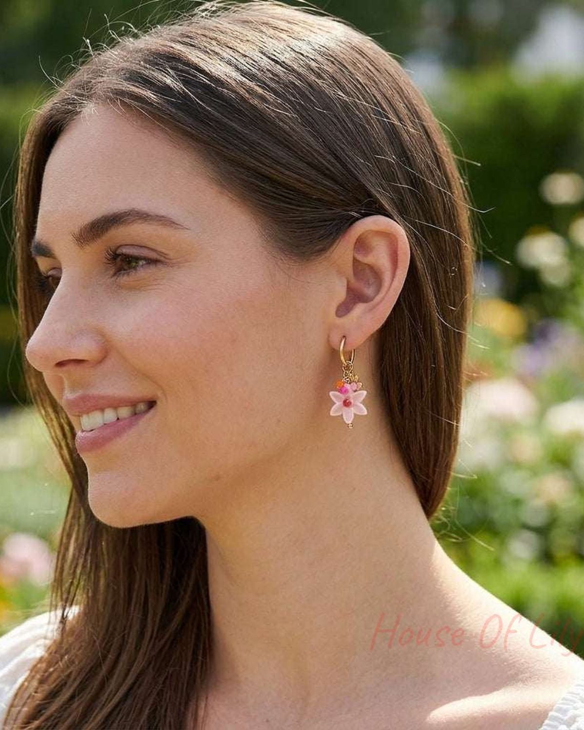 Full-body shot of a woman wearing small floral earrings outdoors, highlighting their delicate size and detailed design.