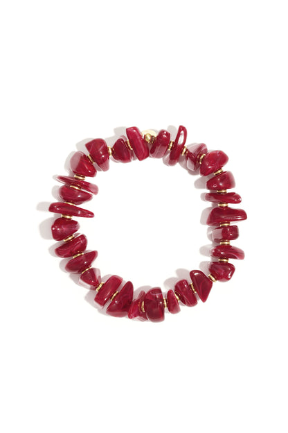 Deep red chunky beaded stretch bracelet with gold-tone spacers on white background