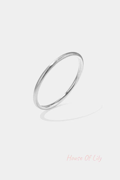 Close-up image of a sleek silver minimalist circle bangle bracelet with smooth finish on white background