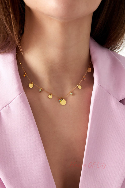 Model wearing the gold disc charm necklace paired with a lilac blazer, showcasing necklace placement around the neck