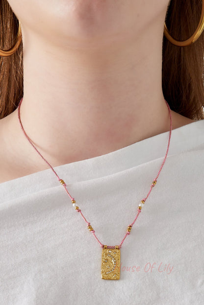 Model showing close detail of the pink cord moon pendant necklace