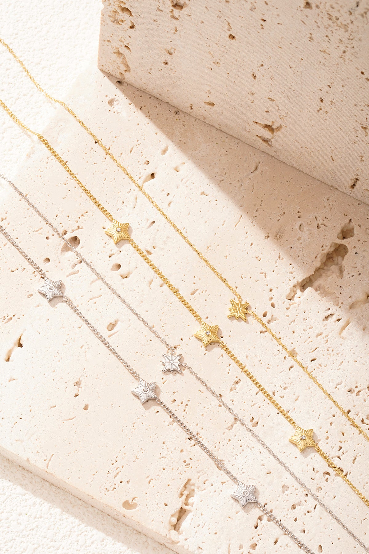 Silver layered star necklace displayed on black premium product card