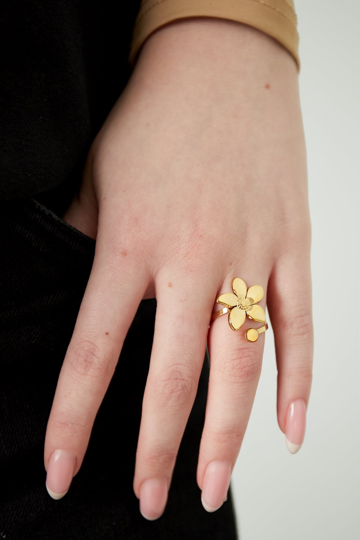 Hand wearing the gold flower statement ring highlighting its size, design, and polished finish