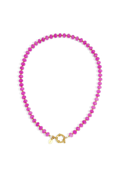 Close-up of a sky blue stone beaded necklace with gold beads and toggle clasp