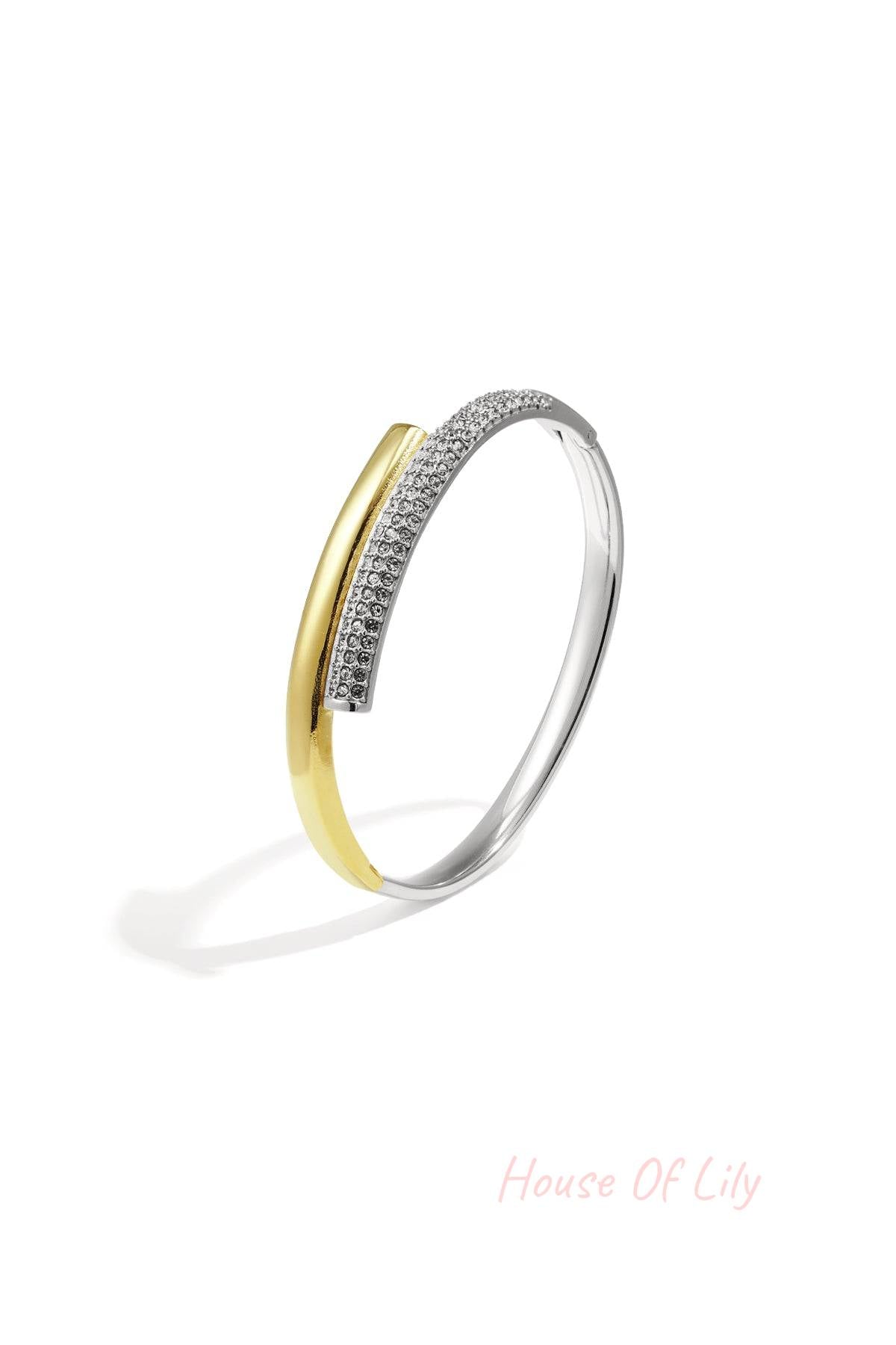 Two-tone gold and silver minimalist bangle featuring a smooth bar and row of embedded crystals on white background