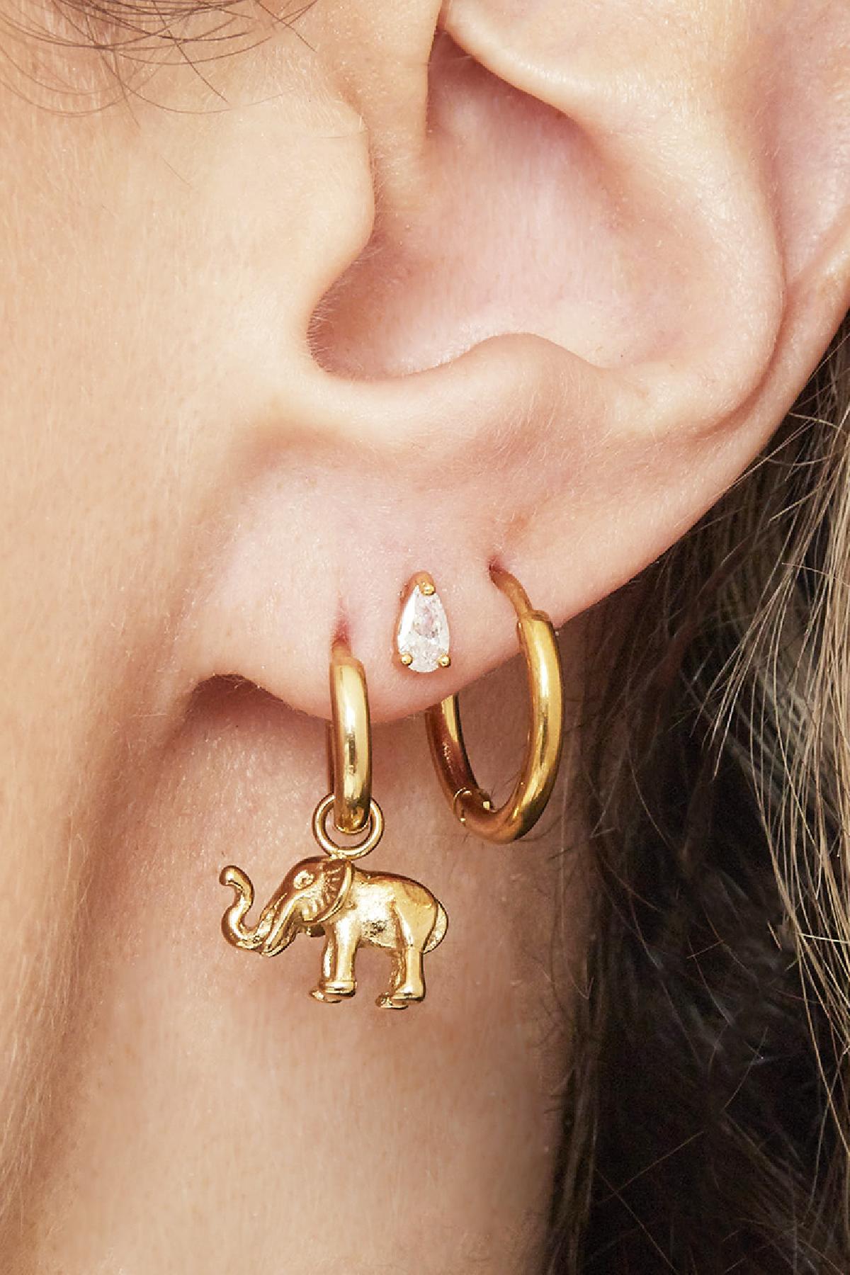 Close-up of ear wearing two gold hoops, one featuring a dangling elephant charm and a small pear-shaped stud