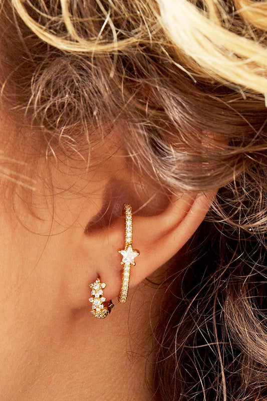 Model wearing star cluster gold hoop earrings showcasing their sparkle and fit