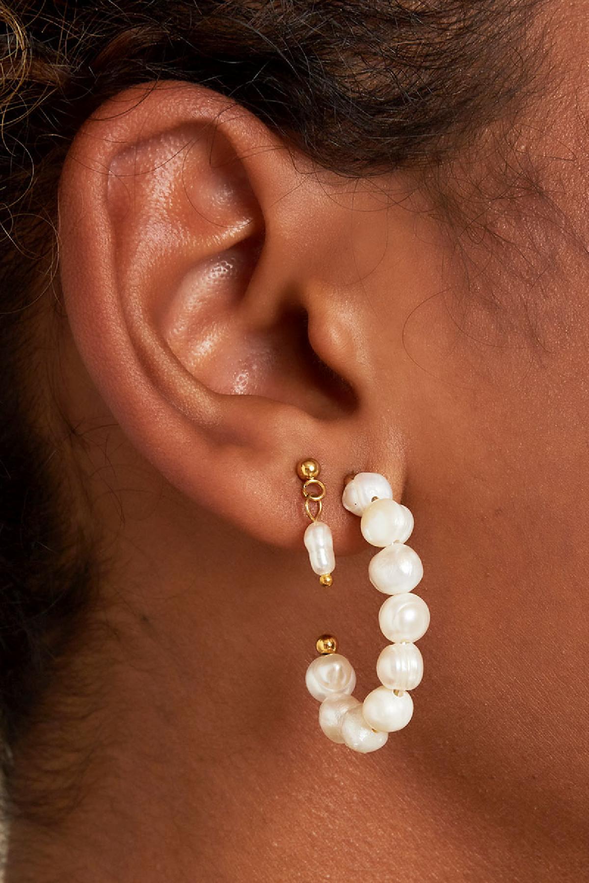 Close-up of ear wearing gold-tone short drop earrings with tiny freshwater pearls and larger pearl hoop earring