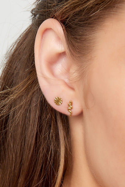 Profile of a woman wearing gold snake stud earring paired with a small gold circular earring