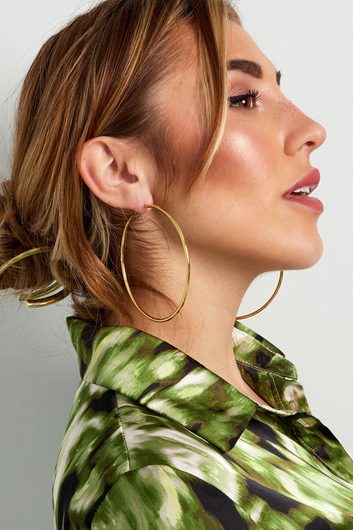 Another side angle of model wearing large gold hoops, showing effortless and youthful style