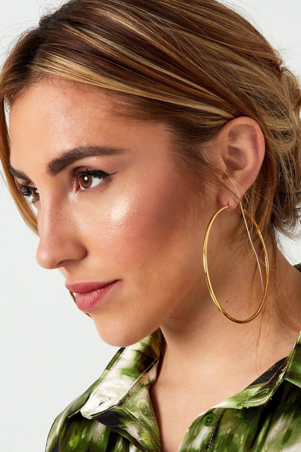 Side profile of model showcasing large gold hoop earrings, highlighting the secure clasp and minimalist design
