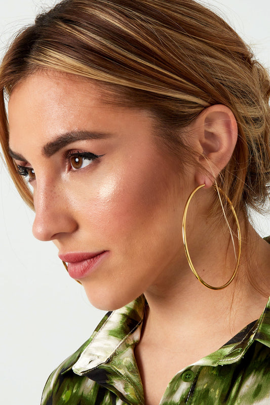 Side profile of model showcasing large gold hoop earrings, highlighting the secure clasp and minimalist design