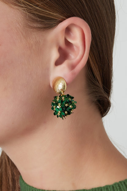 Side view of a woman's ear wearing floral drop earring with gold-tone textured stud and a cluster of green flowers accented with small golden beads.