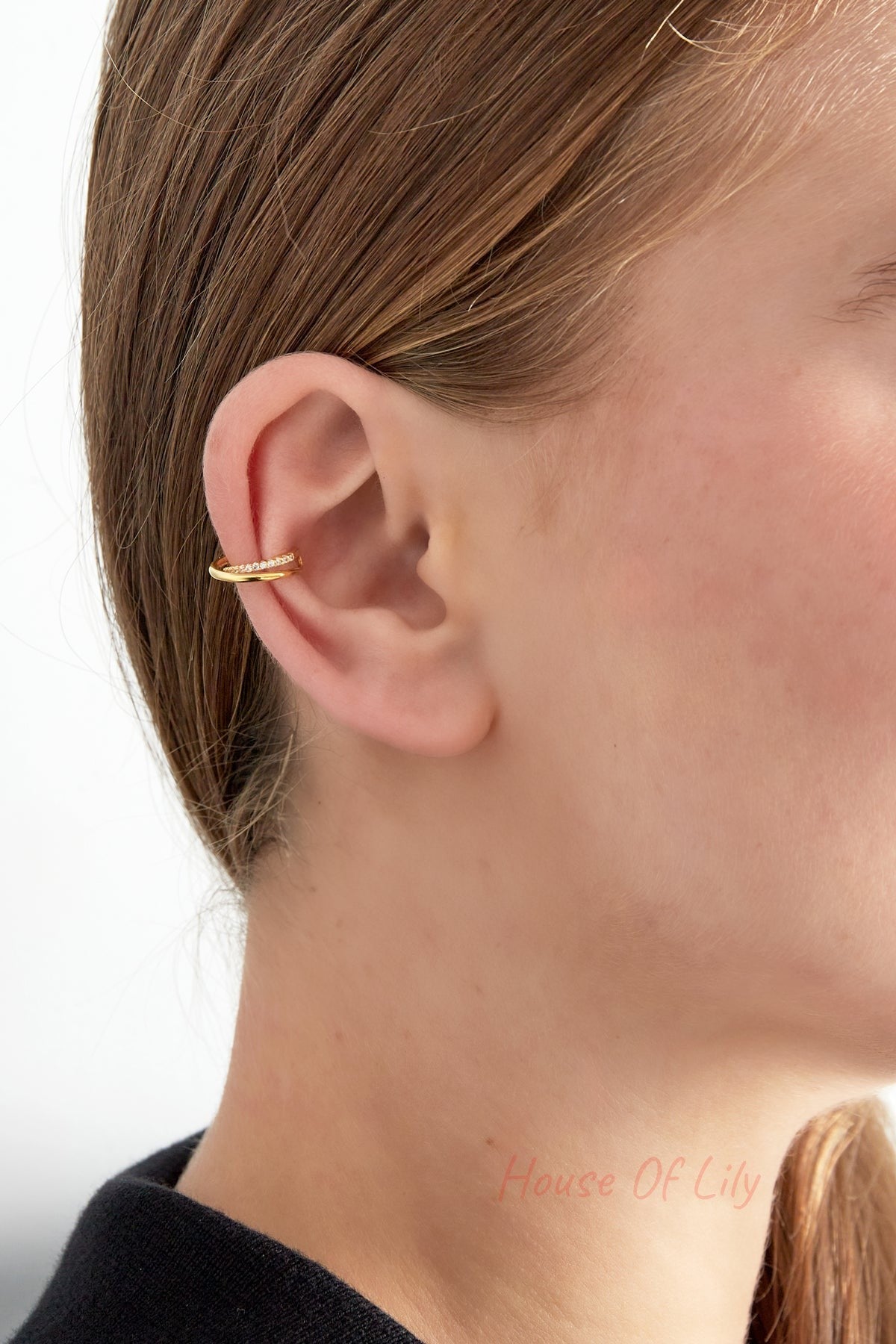 Side profile of a woman wearing the gold spiral ear cuff clipped on the ear's upper cartilage